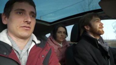 Mutlu Arkadaşlar Arabayla Birlikte Seyahat Eder. Bir grup Turist Aile Seyahati. SUV Panoramik Cam Çatı. Erkek Kadın Kış Giyimi Sonbahar Sezonu. 2x Yavaş çekim 60fps 4K