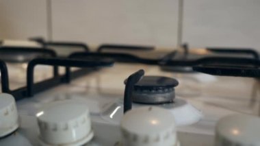 Kadın El Çevirici Tokmağı yakın plan. Gaz ocağını yakıyorum Mavi Alev Eski Metal Kettle 'ı ısıtıyorum. Mutfakta yemek pişirmek. Yavaş çekim 4K