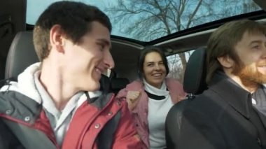 Mutlu Arkadaşlar Arabayla Birlikte Seyahat Eder. Bir grup Turist Aile Seyahati. SUV Panoramik Cam Çatı. Erkek Kadın Kış Giyimi Sonbahar Sezonu. 2x Yavaş çekim 60fps 4K