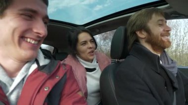 Mutlu Arkadaşlar Arabayla Birlikte Seyahat Eder. Bir grup Turist Aile Seyahati. SUV Panoramik Cam Çatı. Erkek Kadın Kış Giyimi Sonbahar Sezonu. 2x Yavaş çekim 60fps 4K