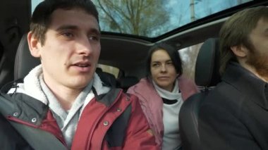 Mutlu Arkadaşlar Arabayla Birlikte Seyahat Eder. Bir grup Turist Aile Seyahati. SUV Panoramik Cam Çatı. Erkek Kadın Kış Giyimi Sonbahar Sezonu. 2x Yavaş çekim 60fps 4K