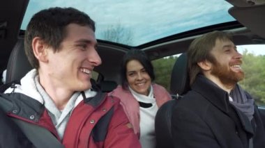 Mutlu Arkadaşlar Arabayla Birlikte Seyahat Eder. Bir grup Turist Aile Seyahati. SUV Panoramik Cam Çatı. Erkek Kadın Kış Giyimi Sonbahar Sezonu. 2x Yavaş çekim 60fps 4K