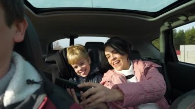 Mutlu Anne ve Çocuk Selfie Fotoğraflı Akıllı Telefon Saat Saati. Yolculuk Aile Seyahati Birlikte Arabayla Seyahat. SUV Panoramik Cam Çatı. Kış Giyimi Sonbahar sezonu. 2x Yavaş çekim 60 fps 4K