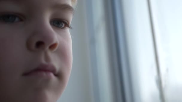 Üzgün Küçük Çocuk Pencerenin Yanında Duruyor Düşünceli Yalnız Çocuk Bekleyin — Stok video