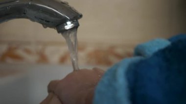 Küçük çocuk tuvalette ellerini musluğun altında suyla yıkıyor. Çocuk hijyenine yakın çekim. 2x Yavaş çekim 60fps 4K