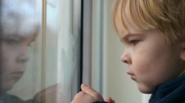 Şirin Çocuk Düşünceli Surat. Ciddi Çocuk Bekliyor, Pencereden Bakıyor ve Düşünüyor. 2x Yavaş çekim 60 FPS 4K