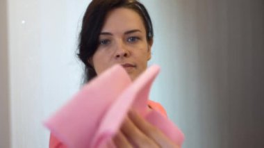 Genç kadın ev işçisi, Evdeki Toz Aynası Gardırobu 'nu temizliyor. 2x Yavaş çekim 60 fps 4K