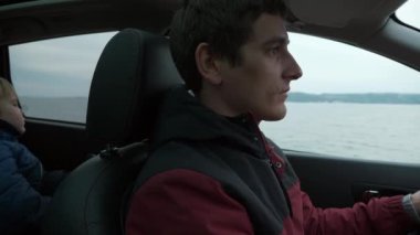River Baraj Barajı 'ndaki Erkek Sürücü Arabası. Aile Seyahati yapan adam SUV aracıyla. Bulutlu Gökyüzü. Sonbahar Kış sezonu. 2x Yavaş çekim 60fps 4K