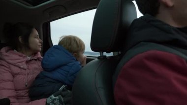 River Reservoir 'daki Araba Penceresinden İzleyen Meraklı Küçük Çocuk. Çocuk Çocuk annesiyle seyahat ediyor. Bulutlu Gökyüzü. Sonbahar Kış sezonu. 2x Yavaş çekim 60fps 4K