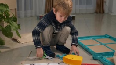 Makas Plastik Detaylarla Kesilen Küçük Çocuk. Whiteboard 'u birleştiren çocuk. Çocuk Yatağı İnşaatçısı. Çocuk Eğitimi Evde Öğreniyor. 2x Yavaş çekim 60fps 4K