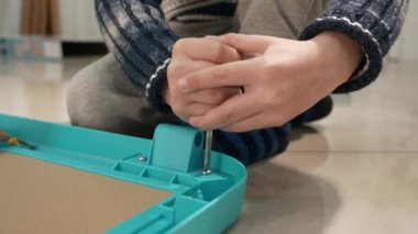 Little Boy, Whiteboard 'u birleştiren tornavidayı sıkılaştırıyor. Çocuk Yatağı İnşaatçısı. Çocuk Eğitimi Evde Öğreniyor. 2x Yavaş çekim 60 fps 4K