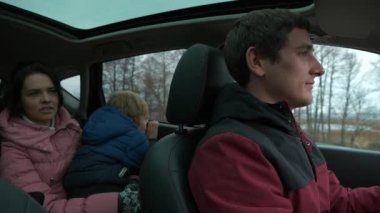 Genç Aile Babası Anne Çocuk Araçla Birlikte Seyahat Ediyor. Country Sahne Arkaplanı Bulutlu Gökyüzü. Sonbahar Kış sezonu. 2x Yavaş çekim 60fps 4K