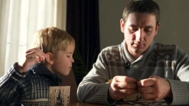 Father with Son Assemble Wooden Toy Truck Constructor. Dad with Child Spend Time Together Handcraft. Winter Holidays Sunny Day Home. 2x Slow motion 60fps 4K