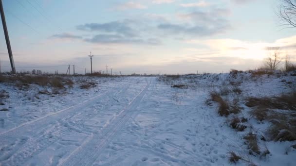 Autospuren Und Menschliche Fußspuren Auf Der Verschneiten Landstraße Feld Country — Stockvideo