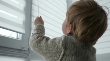 Little Boy Kid Opens Window Roller Shutter Blinds Curtain. Cute Child at Home. 2x Slow motion 60 fps 4K