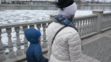 Mother with Child Walk Along City Street. Residential Area Block of Flats Apartments Condominium Buildings. Winter Cold Day. 2x Slow motion 60 fps 4K
