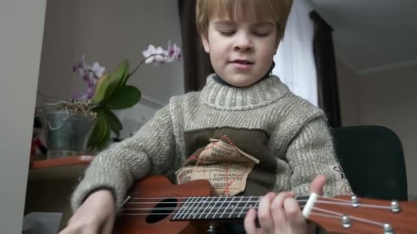 Little Boy Kid Spielt Hause Ukulele Gitarre Kind Singt Und — Stockvideo