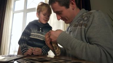 Father with Son Assemble Wooden Toy Truck Constructor. Dad with Child Spend Time Together Handcraft. Winter Holidays Sunny Day Home. 2x Slow motion 60fps 4K