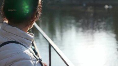 Mother with Child Walk Near Lake Relaxing. Woman and Kid Enjoy Beautiful View on City Cityscape. Spring Sunny Morning. Slow motion 4K