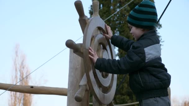 Little Boy Turning Steering Wheel Kid Plays Wooden Ship Playground — Stock Video