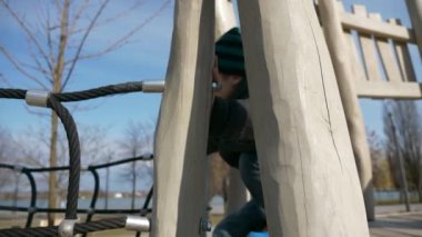 Kid Walks and Climbs on Children Playground. Child Boy Plays Park. City Winter Spring Day. 2x Slow motion 60fps 4K