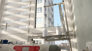 Elektrikli dikiş makinesinde çalışan kadın. Evde Kadın Terzi Çalışması. Güneşli bir gün. 2x Yavaş çekim 60fps 4K