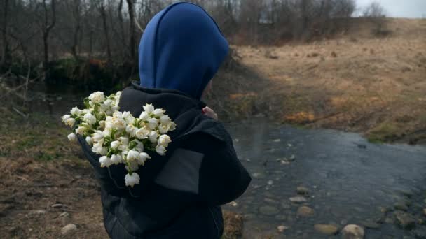 Child Kid Stands Gathered Snowdrop Flowers River Stream Spring Season — Stock Video