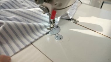 Elektrikli dikiş makinesinde çalışan kadın. Evde Kadın Terzi Çalışması. Güneşli bir gün. 2x Yavaş çekim 60 fps 4K