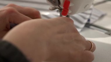 Elektrikli dikiş makinesinde çalışan kadın. Evde Kadın Terzi Çalışması. Güneşli bir gün. 2x Yavaş çekim 60 fps 4K