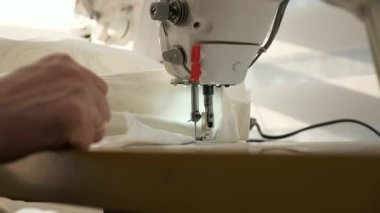 Elektrikli dikiş makinesinde çalışan kadın. Evde Kadın Terzi Çalışması. Güneşli bir gün. 2x Yavaş çekim 60 fps 4K