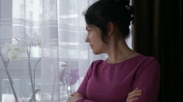 Poważna Kobieta Stoi Myśląc Patrząc Okno Kwiatami Przemyślane Emocje Ekspresyjne — Wideo stockowe