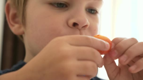 近くで何が起きているのでしょうか かわいい男の子の子供は甘いチェリーフルーツを食べる食事キッチンホームデイダイニングルーム 2倍スローモーション60 Fps — ストック動画