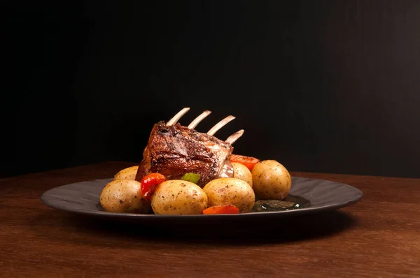 Rack Lamb Vegetables Roasted Potato Dark Plate Wooden Table — Stock Photo, Image