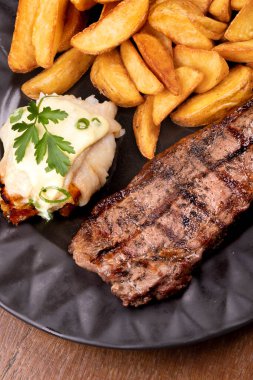 Sörf ve güveç. Izgara biftek ve patatesli kızarmış balık yemeği.