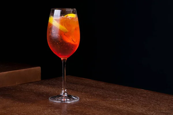 Aperol Spritz Sklo Jiskřivým Ledem Dřevěném Stole Tmavým Pozadím Přední — Stock fotografie