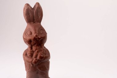 Gri arka plan stüdyo fotoğrafında izole edilmiş çikolatalı Paskalya tavşanı.