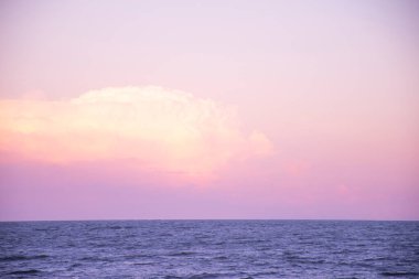 Huzur ve sükunetin doğal manzarası. Okyanus ve bulutlarla dolu gökyüzü ve altın saat.