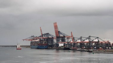 Rotterdam Limanı, Hollanda - 09: 20 2021: Yükleme ve boşaltma için konteyner terminalinin yanında demirlemiş büyük ve küçük konteyner gemileri