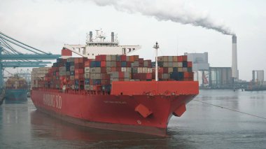 Rotterdam, Hollanda - 10: 20 2021: Bulutlu havada limandan ayrılan ultra büyük konteyner gemisi