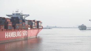 Rotterdam, Hollanda - 10: 20 2021: Karamsar havada limandan ayrılan aşırı büyük konteynır gemileri. Limanda yoğun deniz trafiği