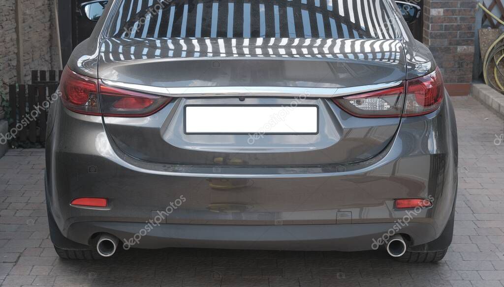 Mykolayiv, Ukraine - 06 15 2022: Car without manufacturer logo parked in the private yard. Rear view of the car. Car with a blank rear license plate. Mock-up of license plate.
