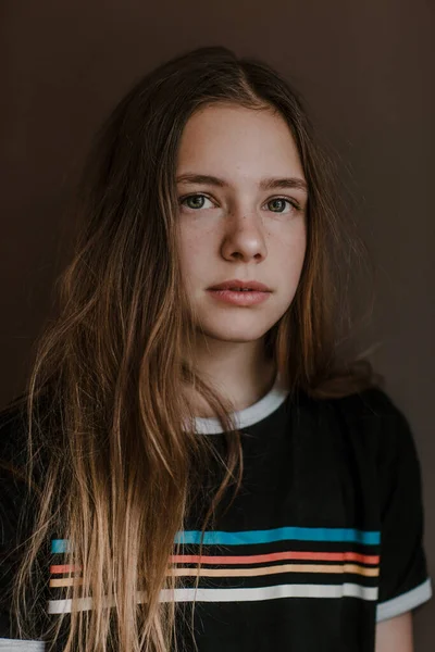 Urocza Nastolatka Długimi Włosami Patrząc Kamerę Ciemnym Tle Studio — Zdjęcie stockowe