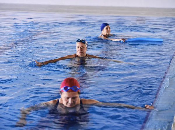 Kobiety Średnim Wieku Strojach Kąpielowych Pływające Basenie Ćwiczące Razem Podczas — Zdjęcie stockowe