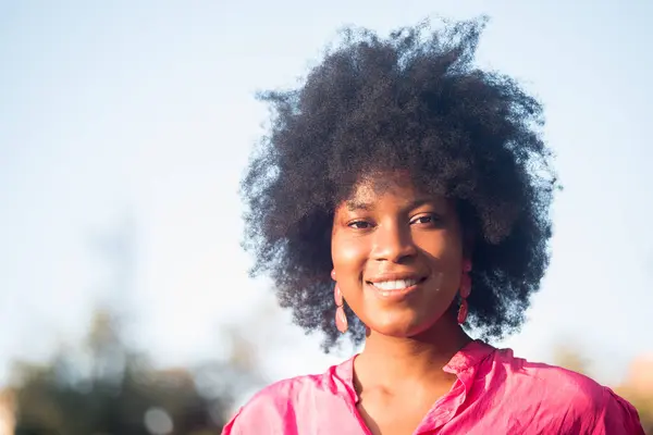 Urocza Afroamerykanka Kręconymi Włosami Uśmiechnięta Kamery Stojąca Słoneczny Dzień Parku — Zdjęcie stockowe