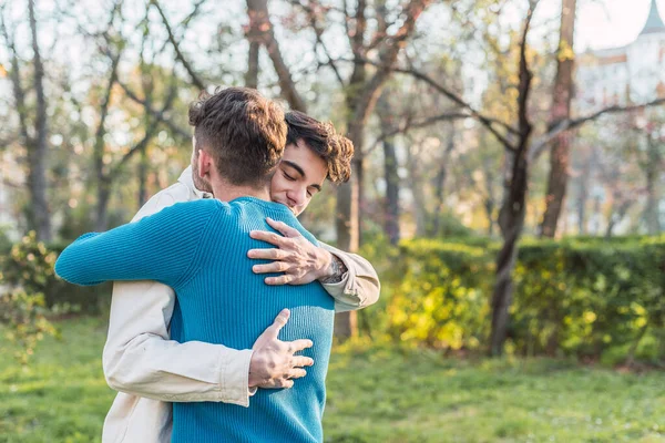 Χαρούμενη Λοατ Ζευγάρι Των Αρσενικών Αγκαλιάζει Ενώ Στέκεται Στο Πάρκο — Φωτογραφία Αρχείου