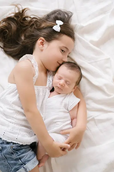 Visão Superior Menina Alegre Abraçando Bebê Adorável Enquanto Deitado Cama — Fotografia de Stock