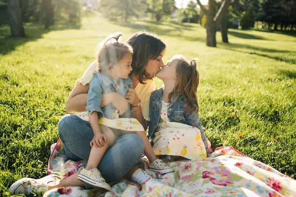 Söta Små Systrar Kysser Lycklig Mor Samtidigt Vilar Tillsammans Filt — Stockfoto