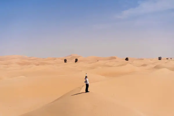 Улыбающаяся Молодая Женщина Повседневной Одежде Стоящая Песчаной Дюне Против Пустыни — стоковое фото