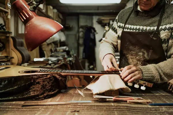 작업장에서 어쿠스틱 기타를 수리하면서 너트를 측정하는 스웨터를 익명의 양성애자 — 스톡 사진