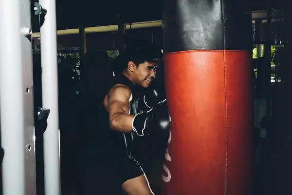 Młody Skupiony Azji Człowiek Trening Boks Wykonując Ciosy Podczas Ćwiczenia — Zdjęcie stockowe